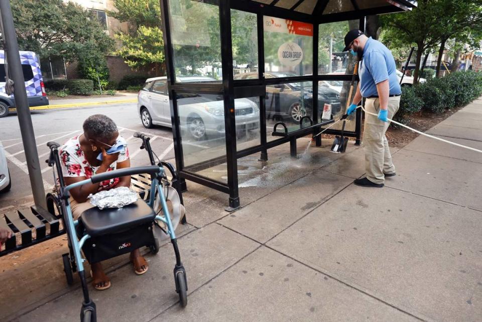 At 7:37 a.m. on Saturday, July 22, 2023, Diane Griffin watches as Christian DeCarlo cleans up vomit on Glenwood Avenue in the Glenwood South neighborhood of Raleigh, N.C.