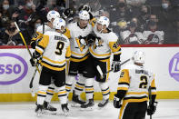 Pittsburgh Penguins' Danton Heinen (43) celebrates his goal against the Winnipeg Jets with Mike Matheson (5), Evan Rodrigues (9) and Dominik Simon (49) during the third period of an NHL hockey game Monday, Nov. 22, 2021, in Winnipeg, Manitoba. (Fred Greenslade/The Canadian Press via AP)