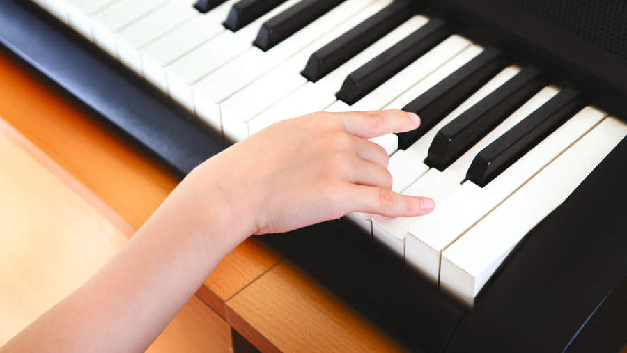  Child's hand on a beginner keyboard . 
