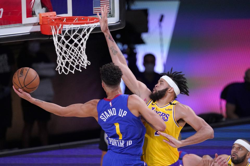 Denver Nuggets forward Michael Porter Jr. (1) attempts to take a shot as Los Angeles Lakers' JaVale McGee, right, defends during the second half an NBA conference final playoff basketball game, Friday, Sept. 18, 2020, in Lake Buena Vista, Fla. (AP Photo/Mark J. Terrill)