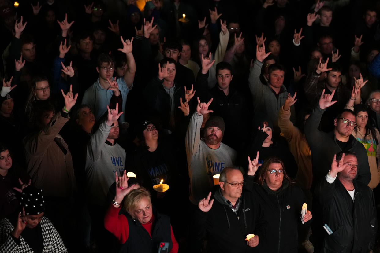 At a nighttime vigil in Maine, dozens of people sign: I love you.