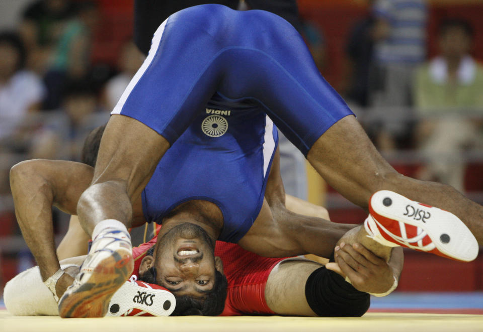 Yogeshwar Dutt of India, in blue, wrestles Kenichi Yumoto of Japan in 60 kilogram category of men's freestyle wrestling competition of the Beijing 2008 Olympics in Beijing, Tuesday, Aug. 19, 2008. (AP Photo/Saurabh Das)