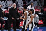 San Antonio Spurs head coach Gregg Popovich, left, talks to Devin Vassell, center, during the first half of an NBA basketball game against the Brooklyn Nets Wednesday, May 12, 2021, in New York. (AP Photo/Frank Franklin II)