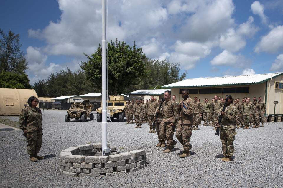 FILE - In this Aug. 26, 2019 file photo released by the U.S. Air Force, airmen from the 475th Expeditionary Air Base Squadron conduct a flag-raising ceremony, signifying the change from tactical to enduring operations, at Camp Simba, Manda Bay, Kenya. Islamic extremists are exploiting possible U.S. military cuts in Africa that have caused a rare bipartisan outcry in Washington, with lawmakers stressing the need to counter China and Russia and rein in a growing threat from fighters linked to the Islamic State group. (Staff Sgt. Lexie West/U.S. Air Force via AP, File)