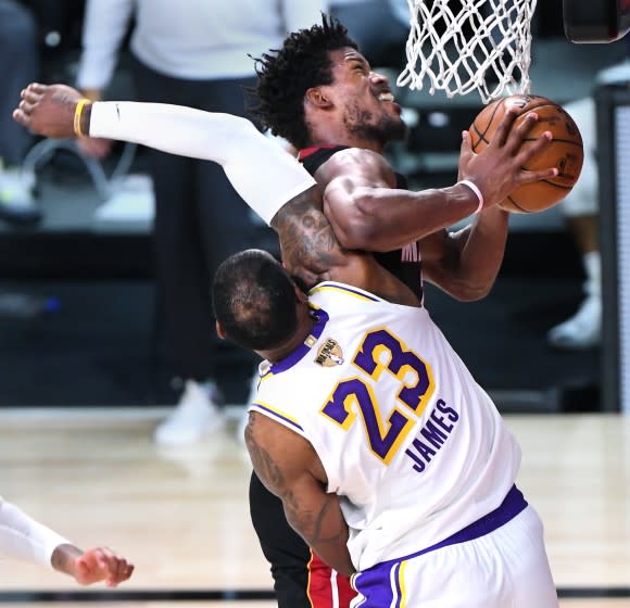 Lakers forward LeBron James fouls Miami forward Jimmy Butler.