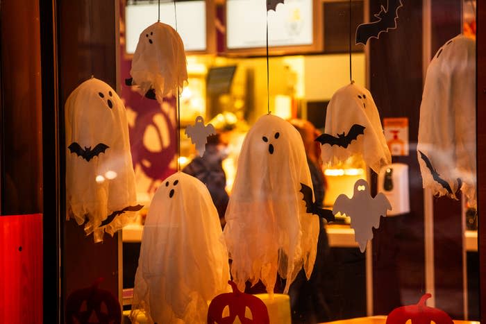 Hanging ghost and bat decorations in a window