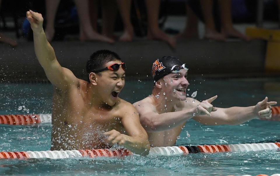 Ames' Joshua Chen and Eli Houseman cheer during a dual meet against Indianola at Ames Municipal Swimming Pool Tuesday in Ames. Ames defeated the Indians, 118-52, in its final meet at the pool.