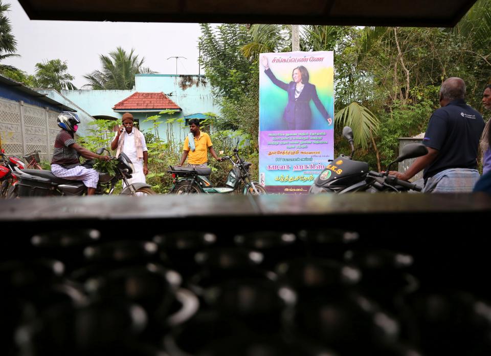 <p>Indian villagers gather outside a local eatery next to a banner featuring US vice president-elect Kamala Harris with a message wishing her best, in Thulasendrapuram, the hometown of Harris' maternal grandfather, south of Chennai, Tamil Nadu state, India. </p> (AP)