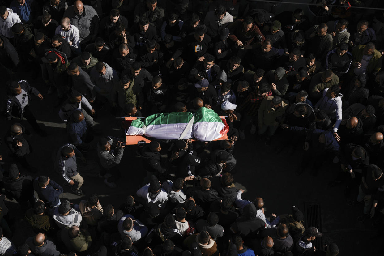 Mourners carry the body of a Palestinian woman, identified as Magda Obaid, 60, during her funeral in the West Bank city of Jenin, Thursday, Jan. 26, 2023. Palestinian health officials said Israeli forces killed at least nine Palestinians, including the Palestinian woman, and wounded several others during a raid in a flashpoint area of the occupied West Bank on Thursday, in one of the deadliest days in months of unrest. The Israeli military said it was conducting an operation to arrest a militant grouping linked to the Palestinian Islamic Jihad, which has a major foothold in the camp. A gun battle erupted, during which the military said it was targeting militants involved in planning and carrying out attacks on Israelis. (AP Photo/Majdi Mohammed)