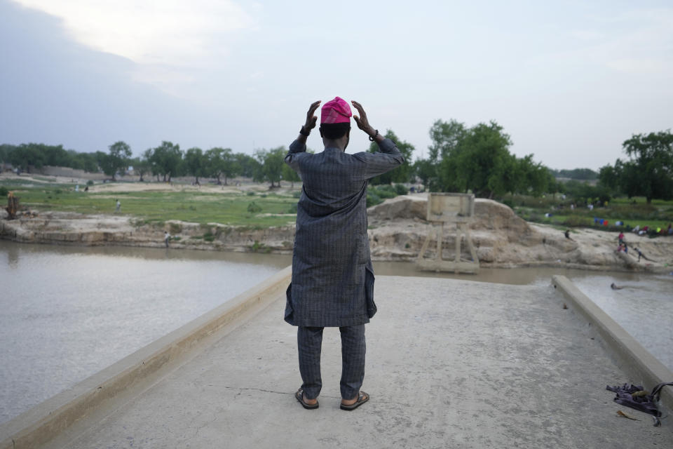 An atheist looks over the river Yobe from a broken bridge in Gashua Nigeria Tuesday, July 11, 2023. Nonbelievers in Nigeria said they perennially have been treated as second-class citizens in the deeply religious country whose 210 million population is almost evenly divided between Christians dominant in the south and Muslims who are the majority in the north. Some nonbelievers say threats and attacks have worsened in the north since the leader of the Humanist Association of Nigeria, Mubarak Bala, was arrested and later jailed for blasphemy. (AP Photo/Sunday Alamba)