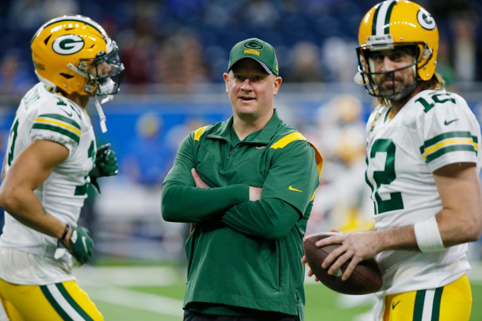 Green Bay Packers offensive coordinator Nathaniel Hackett seen during pregame of a game against the Detroit Lions. At right is Packers QB Aaron Rodgers.