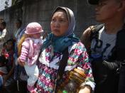 A woman carries a doll she named "Shamia" as she joins other residents that were forced to evacuate a village due to fighting between government soldiers and Muslim rebels from the Moro National Liberation Front (MNLF) in Zamboanga city in southern Philippines September 13, 2013. According to local government officials, the number of evacuees reached about 20,000 people on the fifth day of a government stand-off with the MNLF seeking an independent state. REUTERS/Erik De Castro (PHILIPPINES - Tags: CIVIL UNREST SOCIETY POLITICS)