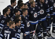 Winnipeg Jets' Paul Stastny (25) poses with his teammates after being presented with a silver stick prior to his 1,000th NHL hockey game, against the Vancouver Canucks on Tuesday, May 11, 2021, in Winnipeg, Manitoba. (Fred Greenslade/The Canadian Press via AP)