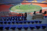 Member of bomb disposal squad from Gujarat Police uses a sniffer dog to scan the stands at Sardar Patel Gujarat Stadium in Ahmedabad