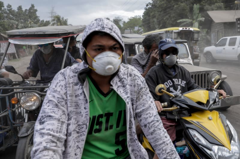 Residents affected by the erupting Taal Volcano leave their town after authorities allowed them to collect belongings and abandoned animals in Agoncillo, Batangas