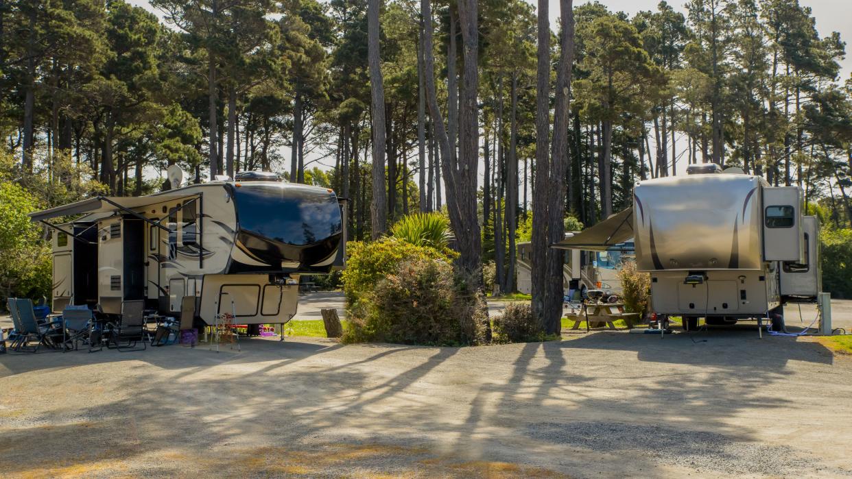 5th wheel trailers parked at a Rv resort amongst the trees