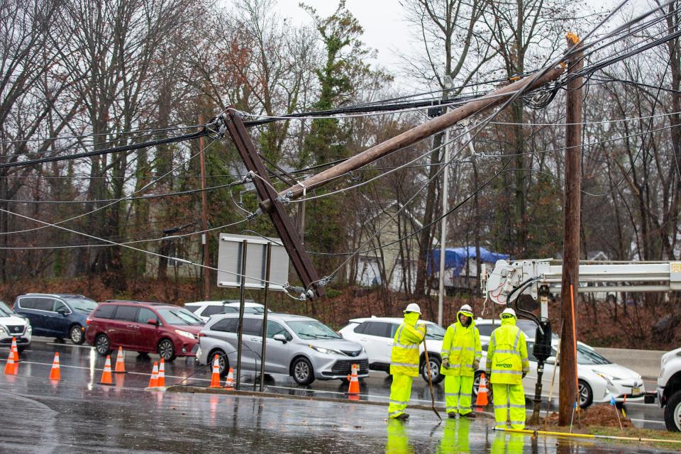 A Verizon work crew works on replacing a broken telephone pole on the corner of Route 9 South and Route 33 in the rain in Freehold, NJ Monday, December 18, 2023.