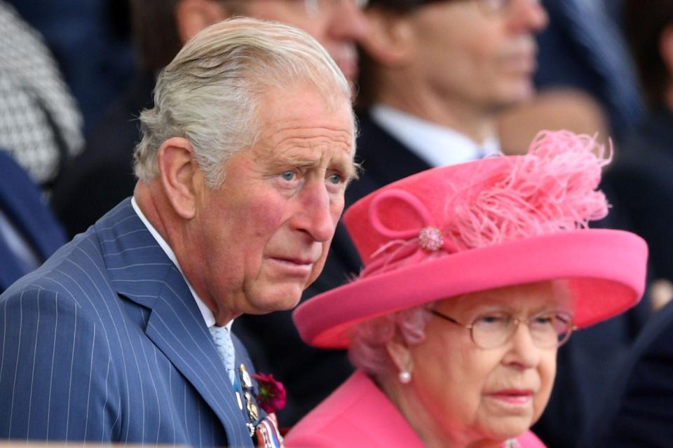 Queen Elizabeth and King Charles (then Prince Charles) sit together at a D-Day anniversary event in 2019