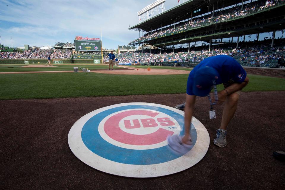 Jun 19, 2017; Chicago, IL, USA; A member of the grounds crew wipes off the Chicago Cubs' on deck logo prior to a game against the San Diego Padres at Wrigley Field. Mandatory Credit: Patrick Gorski-USA TODAY Sports