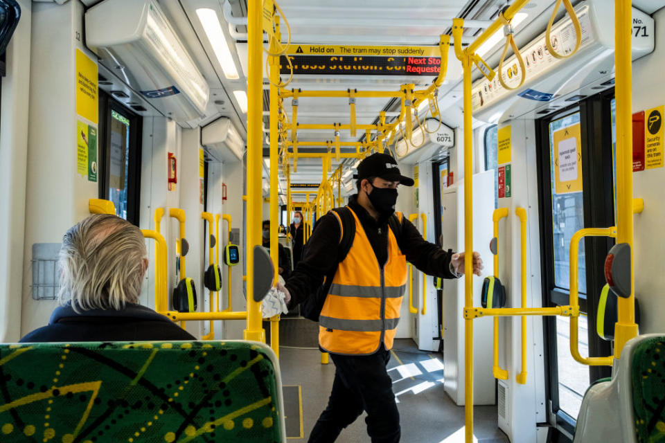 A worker wearing a face mask sanitises the tram during the lockdown in Melbourne. Source: Getty