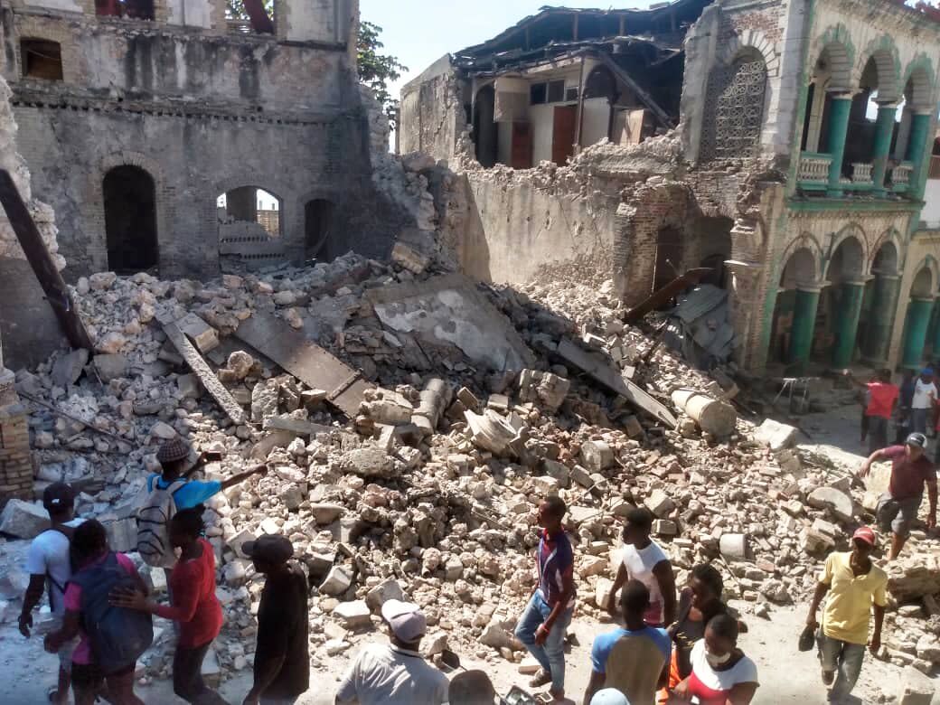 A photo shows damaged buildings as people inspect after a 7.2 magnitude earthquake struck the country on August 14, 2021, in Jeremie, Haiti. The earthquake's epicenter was 12 kilometers (7.5 miles) northeast of Saint-Louis-du-Sud, with a depth of 10 kilometers (6 miles).