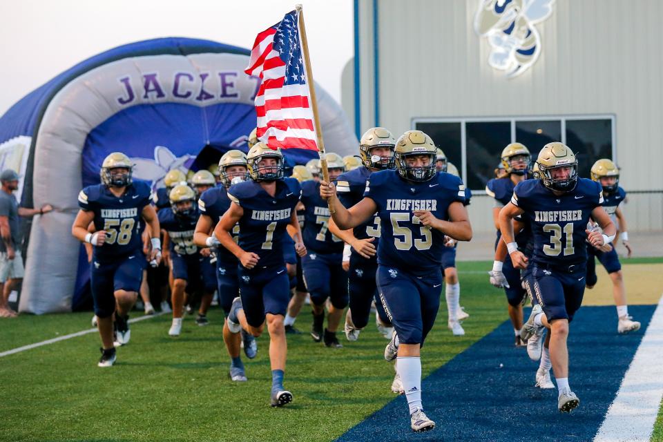 Kingfisher players run on the field for a home game Friday.