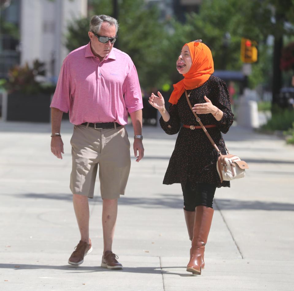 Lamise ElBetar, who is leaving Akron and the country soon, walks with her mentor Tim Gill on Main Street in Akron.