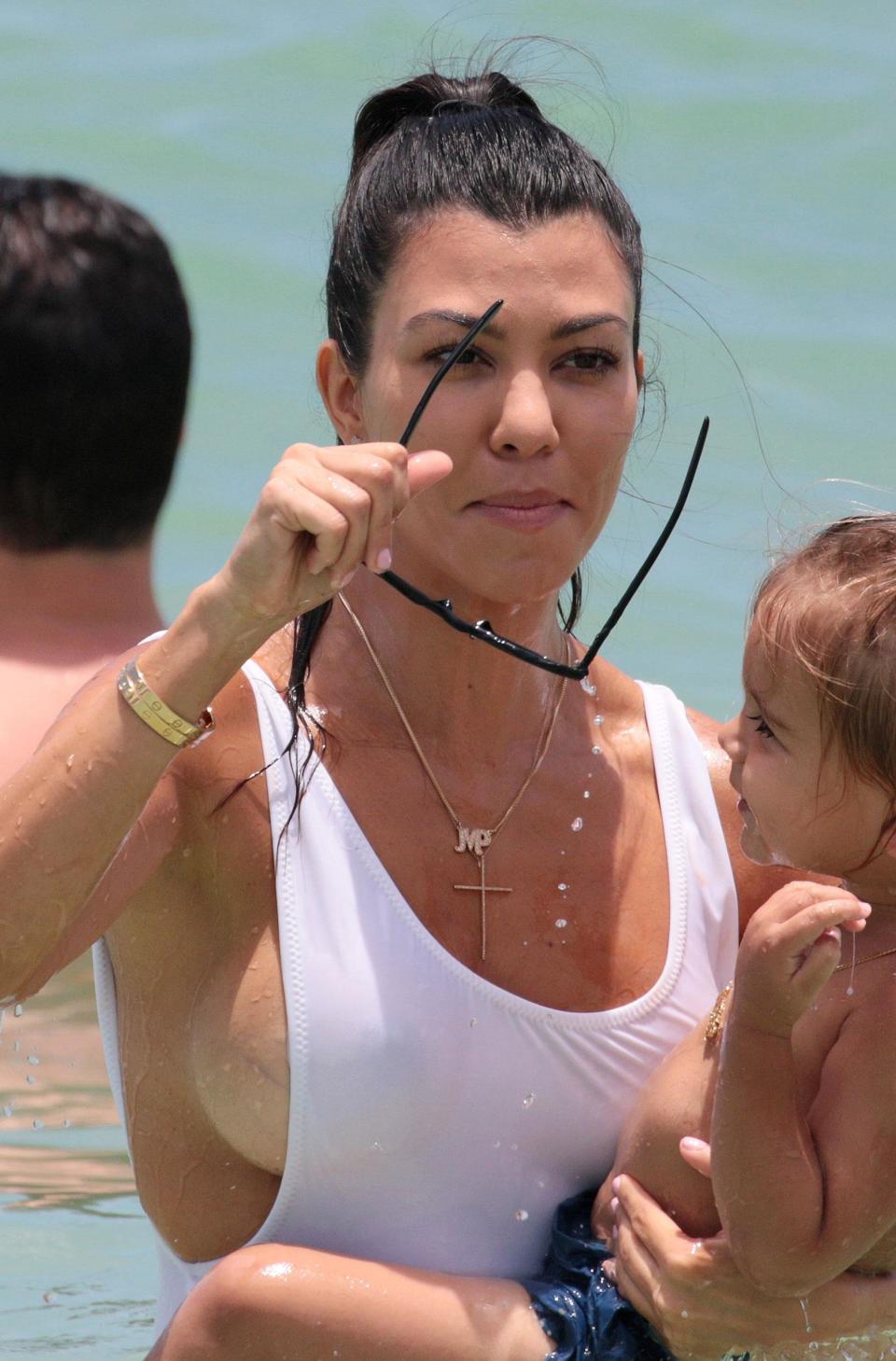 Kourtney flashes the flesh in white hot swimsuit