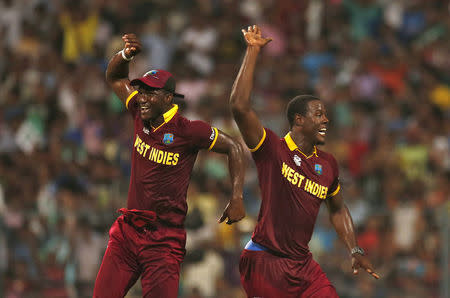 Cricket - England v West Indies - World Twenty20 cricket tournament final - Kolkata, India - 03/04/2016. West Indies Carlos Brathwaite (R) celebrates with his captain Darren Sammy after taking the wicket of England's Joe Root. REUTERS/Adnan Abidi