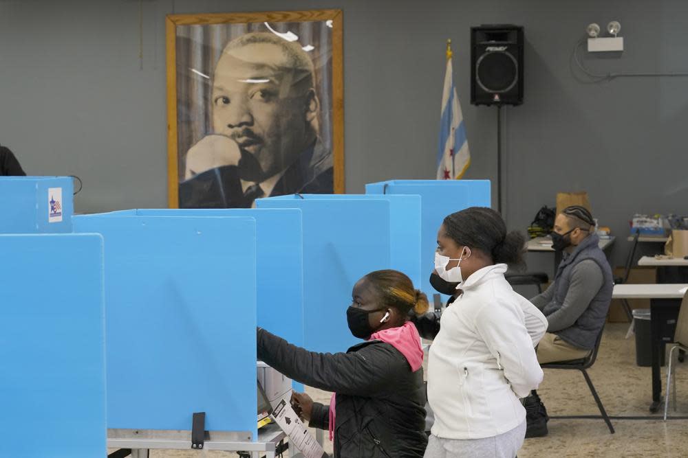 Jeniya Garrett, right, watches her aunt Catherina Neal vote on Election Day on Nov. 3, 2020, at the Dr. Martin Luther King Community Center in the Bronzeville neighborhood of Chicago. Illinois voters have the chance to sign up to send their ballots for the November 2022 election and spring elections by mail — forever. Elections officials are sending applications for permanent permission to vote by mail to each of the state’s 8 million registered voters. (AP Photo/Charles Rex Arbogast, File)