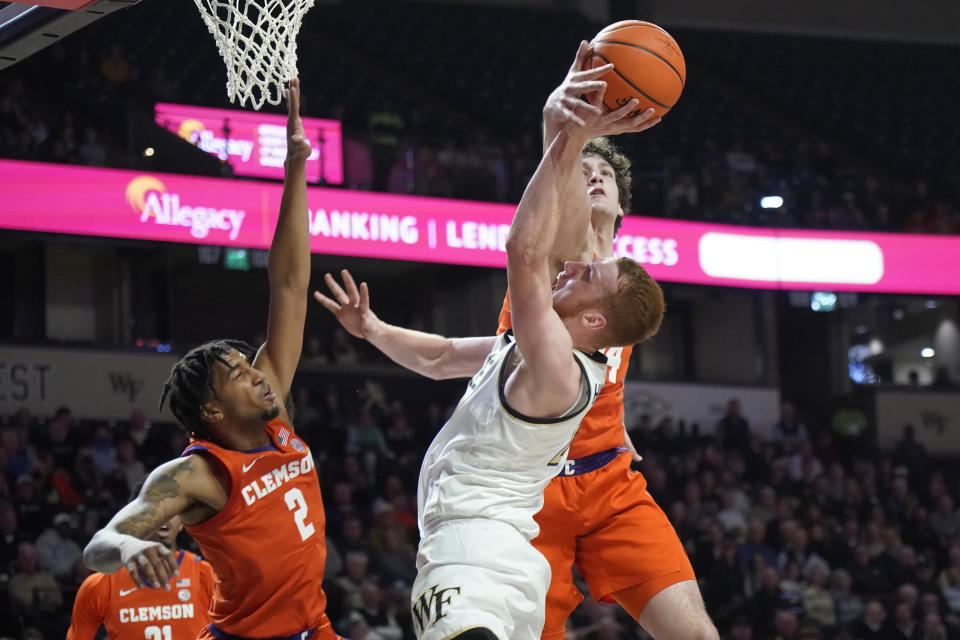 Wake Forest guard Cameron Hildreth, right, is fouled as he drives against Clemson guard Dillon Hunter, left, and PJ Hall, back, during the first half of an NCAA college basketball game in Winston-Salem, N.C., Tuesday, Jan. 17, 2023. (AP Photo/Chuck Burton)