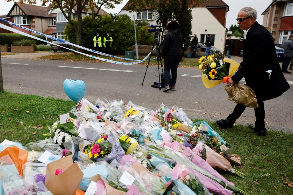 A wel-wisher lays a floral tribute at the scene of the fatal stabbing of Conservative British lawmaker David Amess, at Belfairs Methodist Church in Leigh-on-Sea, a district of Southend-on-Sea, in southeast England on October 16, 2021. - The fatal stabbing of British lawmaker David Amess was a terrorist incident, police said Saturday, as MPs pressed for tougher security in the wake of the second killing of a UK politician while meeting constituents in just over five years. (Photo by Tolga Akmen / AFP) (Photo by TOLGA AKMEN/AFP via Getty Images)