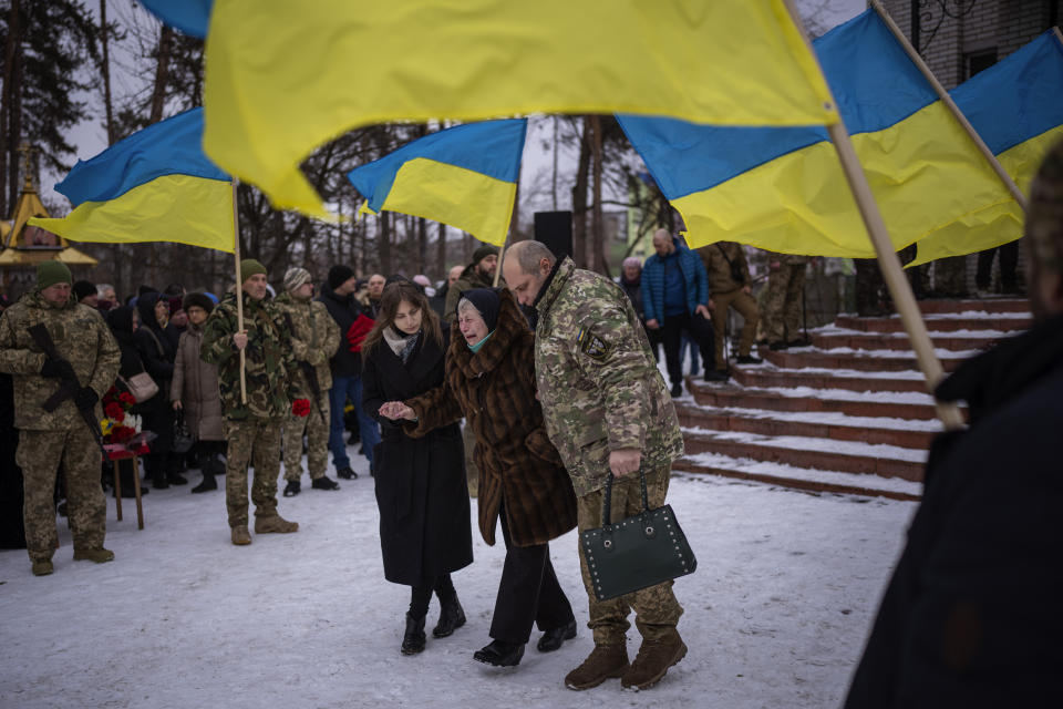 Nina Nikiforovа, 80, center, cries as she leaves a church after attending the funeral of her son Volodymyr, 50, a Ukrainian military serviceman who was killed in the east of the country in Kyiv, Ukraine, Saturday, Feb. 11, 2023. (AP Photo/Emilio Morenatti)