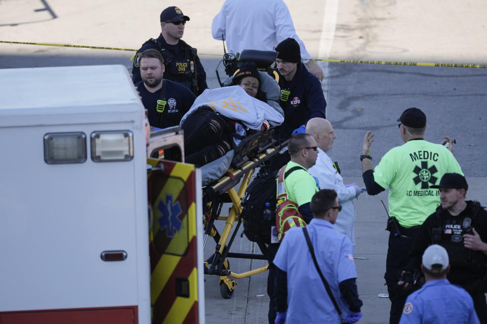 A person is taken to an ambulance after an incident following the Kansas City Chiefs victory parade in Kansas City, Mo., Wednesday, Feb. 14, 2024. The Chiefs defeated the San Francisco 49ers Sunday in the NFL Super Bowl 58 football game. (AP Photo/Charlie Riedel)