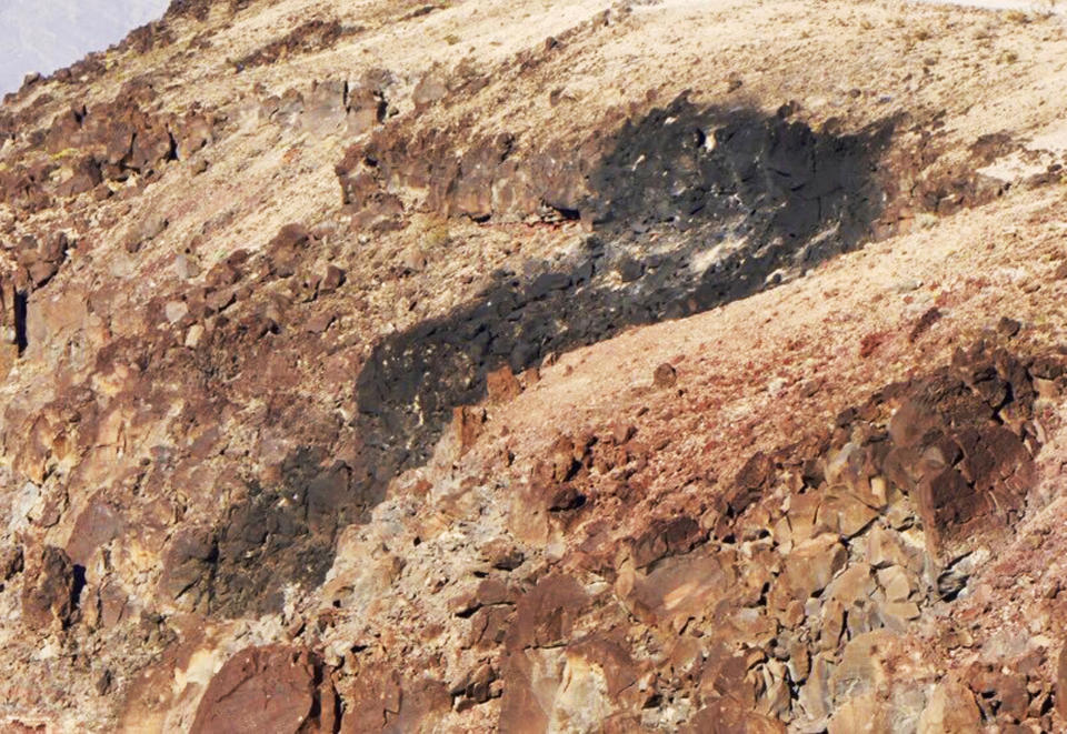 This photo taken from video provided by KABC-TV shows where a Navy fighter jet crashed Wednesday, July 31, 2019, in Death Valley National Park, Calif., injuring multiple people who were at a scenic overlook where aviation enthusiasts routinely watch military pilots speeding low through a chasm dubbed Star Wars Canyon, officials said. The crash sent dark smoke billowing in the air, said Aaron Cassell, who was working at his family's Panamint Springs Resort about 10 miles (16 kilometers) away. A search was underway for the pilot of the single-seat F/A-18 Super Hornet that was on a routine training mission. (KABC-TV via AP)