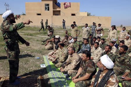 Shi'ite cleric Ahmed al-Rubaei (L) speaks with Iraqi soldiers and Shiite fighters in Udhaim dam, north of Baghdad March 1, 2015. REUTERS/Thaier Al-Sudani