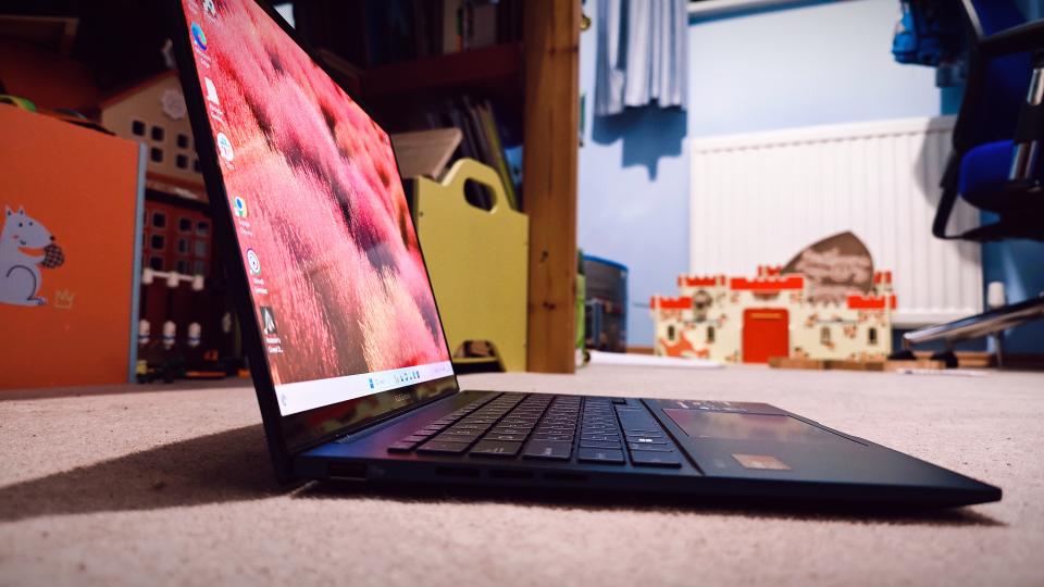 A blue ASUS Zenbook 14 OLED (UX3405) on a carpeted floor