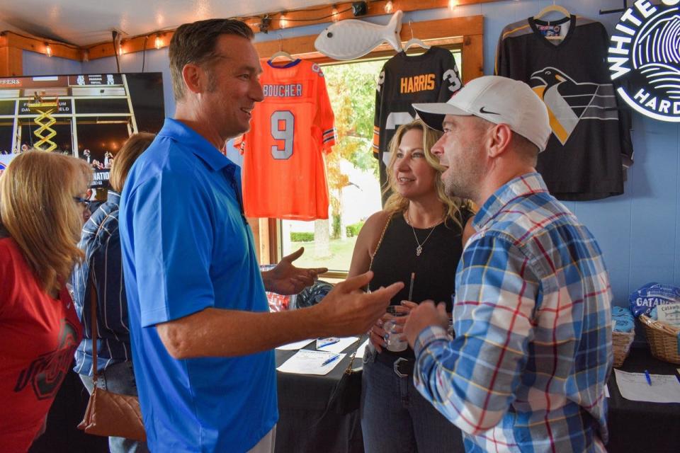 Jerseys of Hope founder John Biemer, left, talks with Debbie and Rocky Fox at The Catawba Inn.