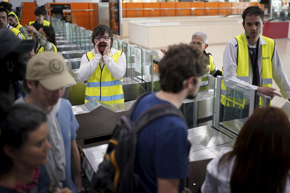 Employees try to give directions to passengers crowded at the entrance to the platforms, at Sants train station in Barcelona, Sunday, May 12, 2024. Catalonia's commuter rail service said it was forced to shut down several train lines due to the robbery of copper cables from an installation near Barcelona. Potentially thousands of voters had trouble reaching their polling stations after Catalonia's commuter rail service had to shut down several train lines due to what officials said was the robbery of copper cables from an installation near Barcelona. (AP Photo/Joan Mateu Parra)