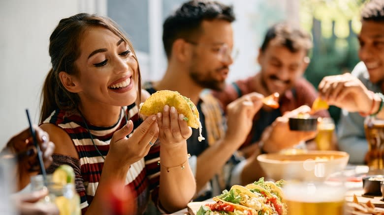 woman eating tacos with friends 