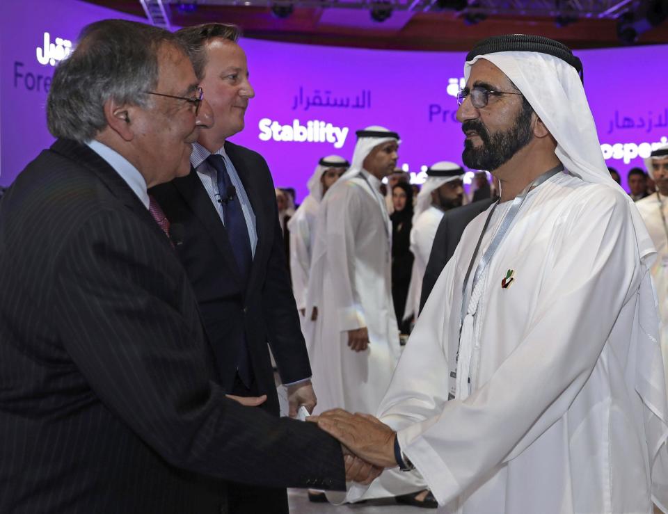 In this photo released by Emirates News Agency, WAM, Sheikh Mohammed bin Rashid Al Maktoum, UAE prime minister and ruler of Dubai, right, shakes hands with former CIA director Leon Panetta, left, standing next to David Cameron, former Prime Minister of the United Kingdom, during the opening day of Arab Strategy Forum in Dubai, United Arab Emirates, Wednesday, Dec. 14, 2014. (Emirates News Agency via AP)