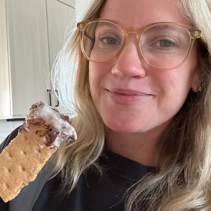 the author dipping a graham cracker in the dutch oven smores