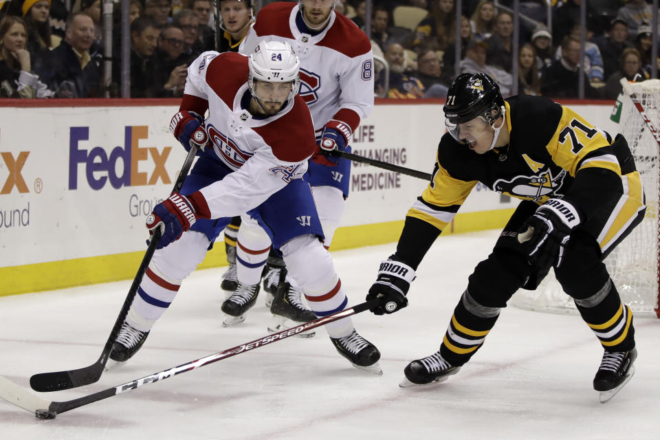 Pittsburgh Penguins' Evgeni Malkin pokes the puck off the stick of Montreal Canadiens' Phillip Danault (24) during the second period of an NHL hockey game in Pittsburgh, Tuesday, Dec. 10, 2019. (AP Photo/Gene J. Puskar)