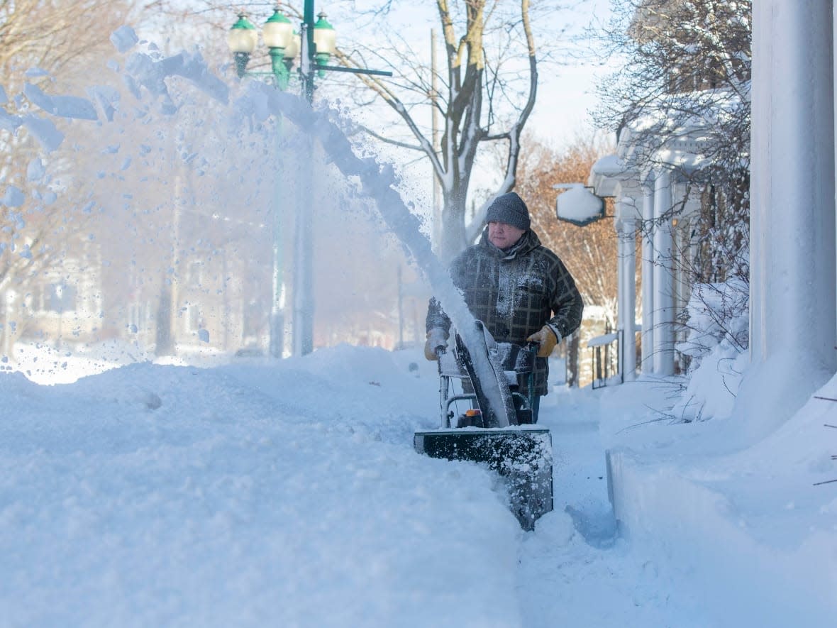 Pedro Alvarez clear snow from a sidewalk in Brockville, Ont., on Sunday. (Lars Hagberg/CBC News - image credit)