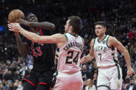 Toronto Raptors' Pascal Siakam, left, tries to shoot as Milwaukee Bucks' Pat Connaughton, center, defends Grayson Allen watches during the second half of an NBA basketball game Thursday, Dec. 2, 2021, in Toronto. (Chris Young/The Canadian Press via AP)