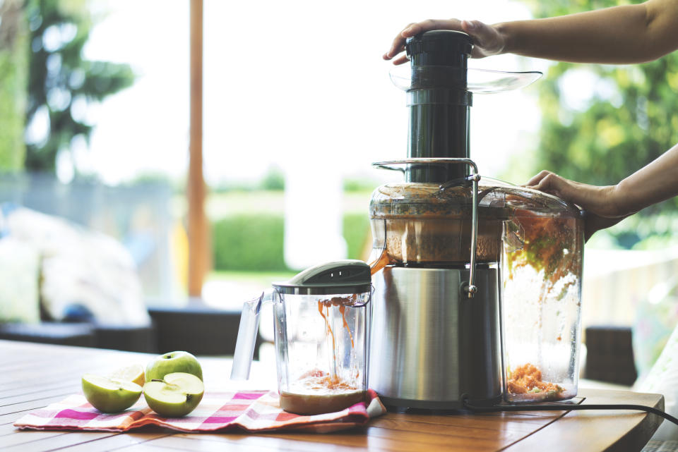 Making fresh fruit juice with whole fruit juicer at home