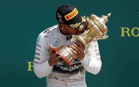 Formula One - F1 - British Grand Prix 2015 - Silverstone, England - 5/7/15 Mercedes' Lewis Hamilton celebrates his win on the podium with the trophy Reuters / Phil Noble