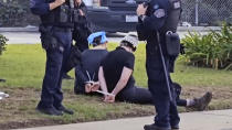 This video still image provided by KABC-TV shows protesters being detained prior to arrested by Los Angeles police officers on Wednesday, Dec. 27, 2023 near Los Angeles International Airport. Pro-Palestinian protesters briefly blocked entrance roads to airports in New York and Los Angeles on Wednesday, forcing some travelers to set off on foot to bypass the jammed roadway. (KABC-TV via AP)