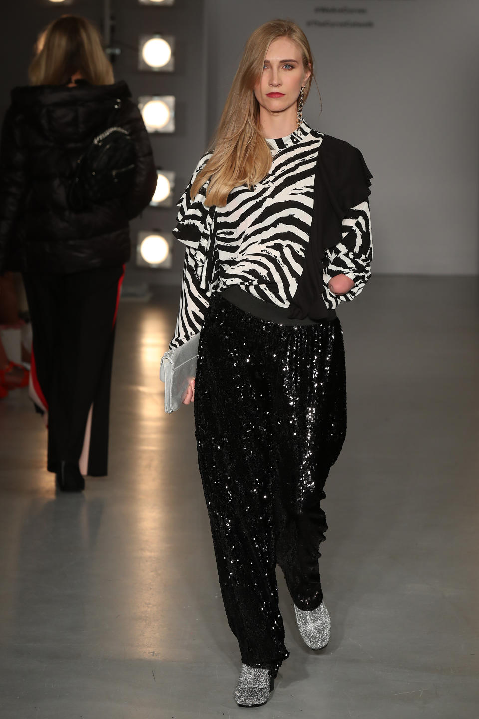 <p>In a zebra print top and sequined trousers. </p>