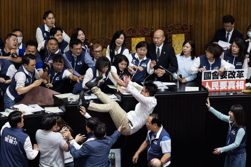 立法院會17日晚間處理藍白所提國會改革相關法案，民進黨立委郭國文（卡其色長褲者）嘗試占領主席台以阻止會議繼續進行，朝野立委爆發衝突，過程中郭國文意外摔下主席台。（中央社）